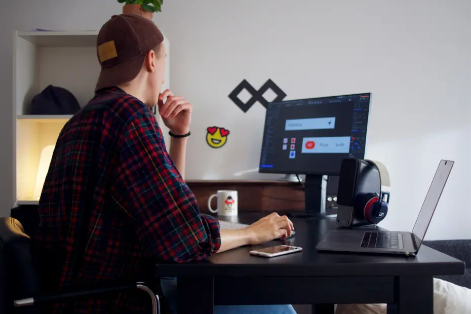 freelancer en design graphique travaillant sur son ordinateur portable et écran de bureau