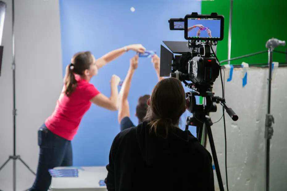tournage en studio avec caméra professionnelle et actrice devant fond bleu