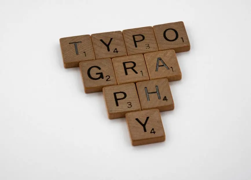 Close-up of wooden Scrabble tiles spelling 'Typography' on a white background.